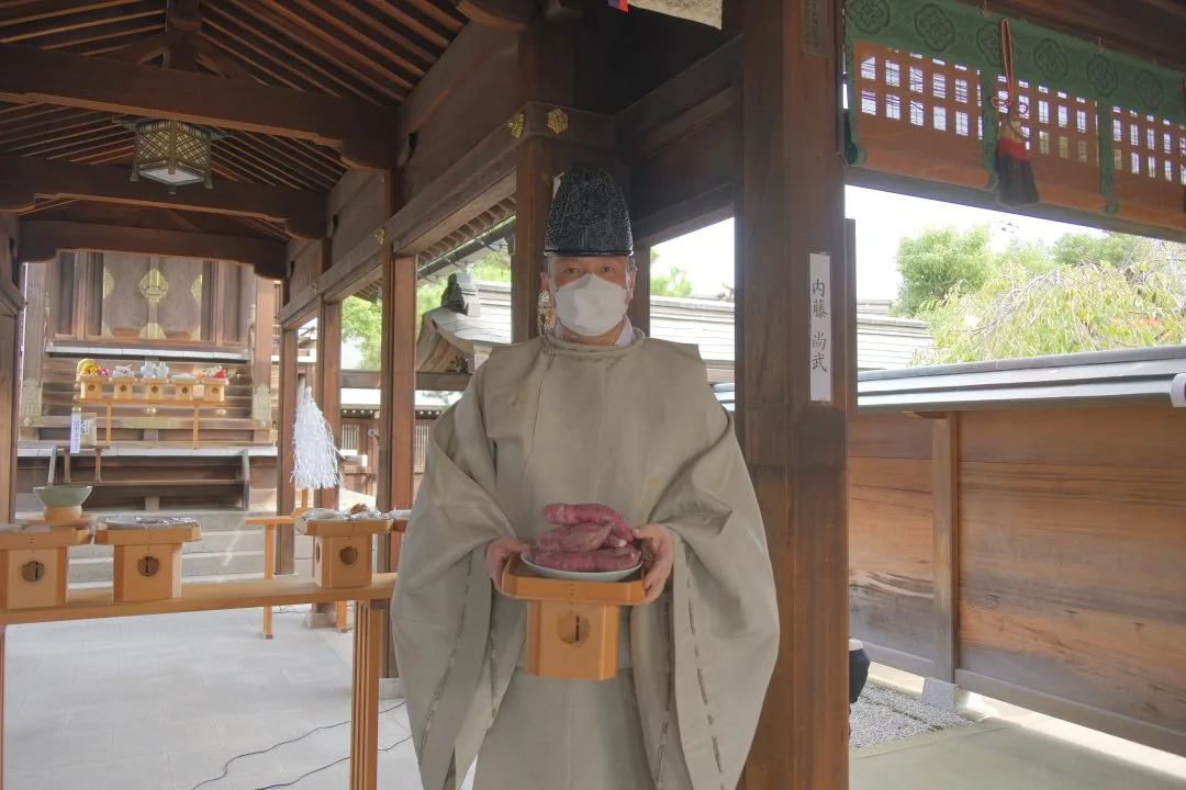 尼芋奉納祭の開催案内に掲載された、尼いもを奉納する様子の写真