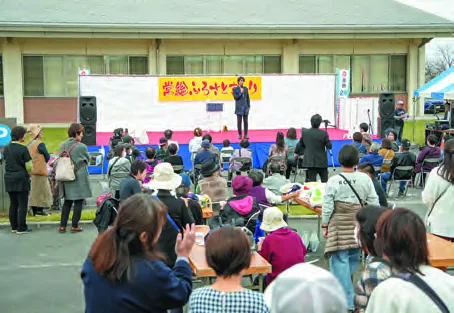 常総ふるさとまつりのステージを楽しむ来場者（当年市広報が掲載する過去開催写真）