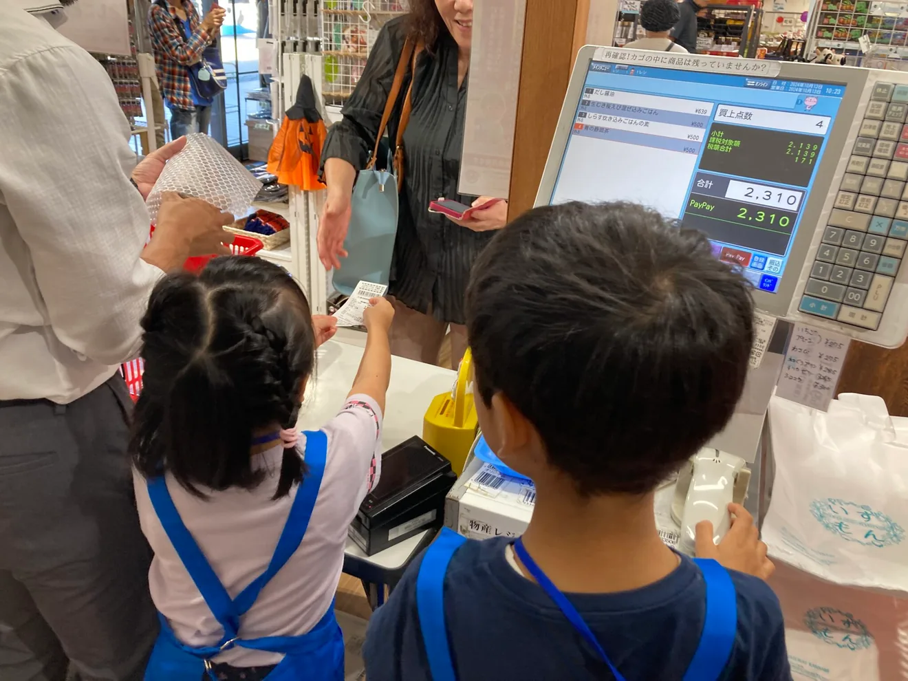 今回の仕事体験案内に掲載された、子どもがレジ操作をする参考写真（撮影年未確認）
