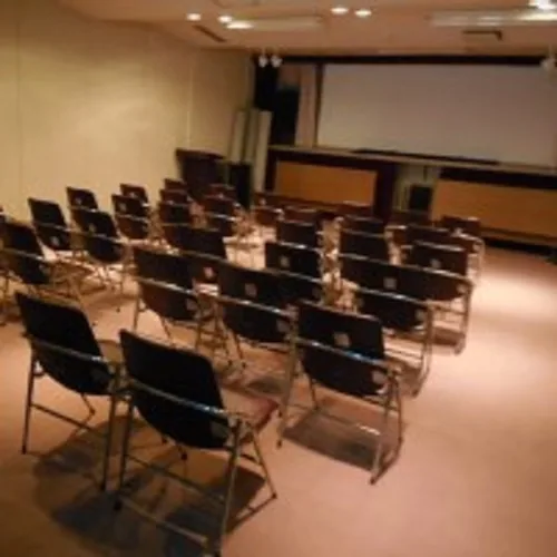 公式の今回案内に掲載された映画会の会場　スクリーンの前に椅子が並んでいる様子の写真（紹介写真）