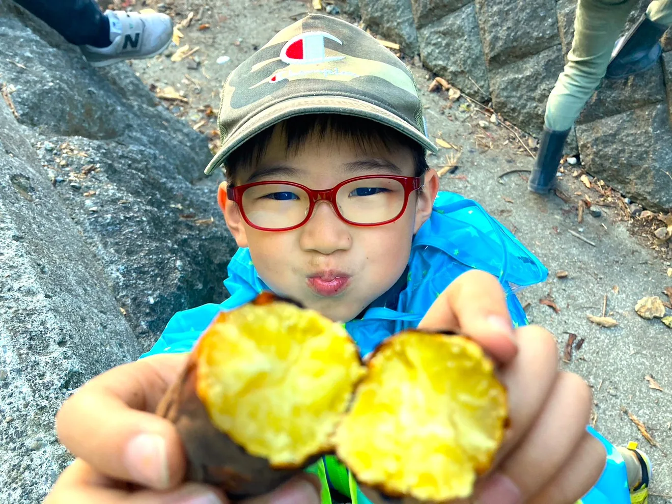 主催者の今回の案内に使われている、焼き芋を手にする子どもの過去の体験写真