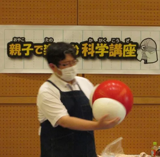 親子で楽しむ科学講座の紹介に使われている、講師が風船を使う実験の参考写真