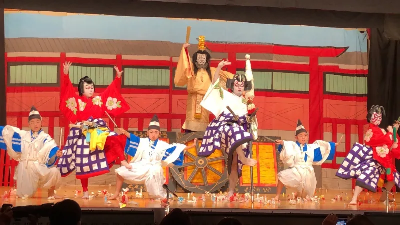 岐阜県の現行保存会紹介が掲載する、坂下歌舞伎保存会の過去の舞台写真。子どもと大人の役者が演じる場面。