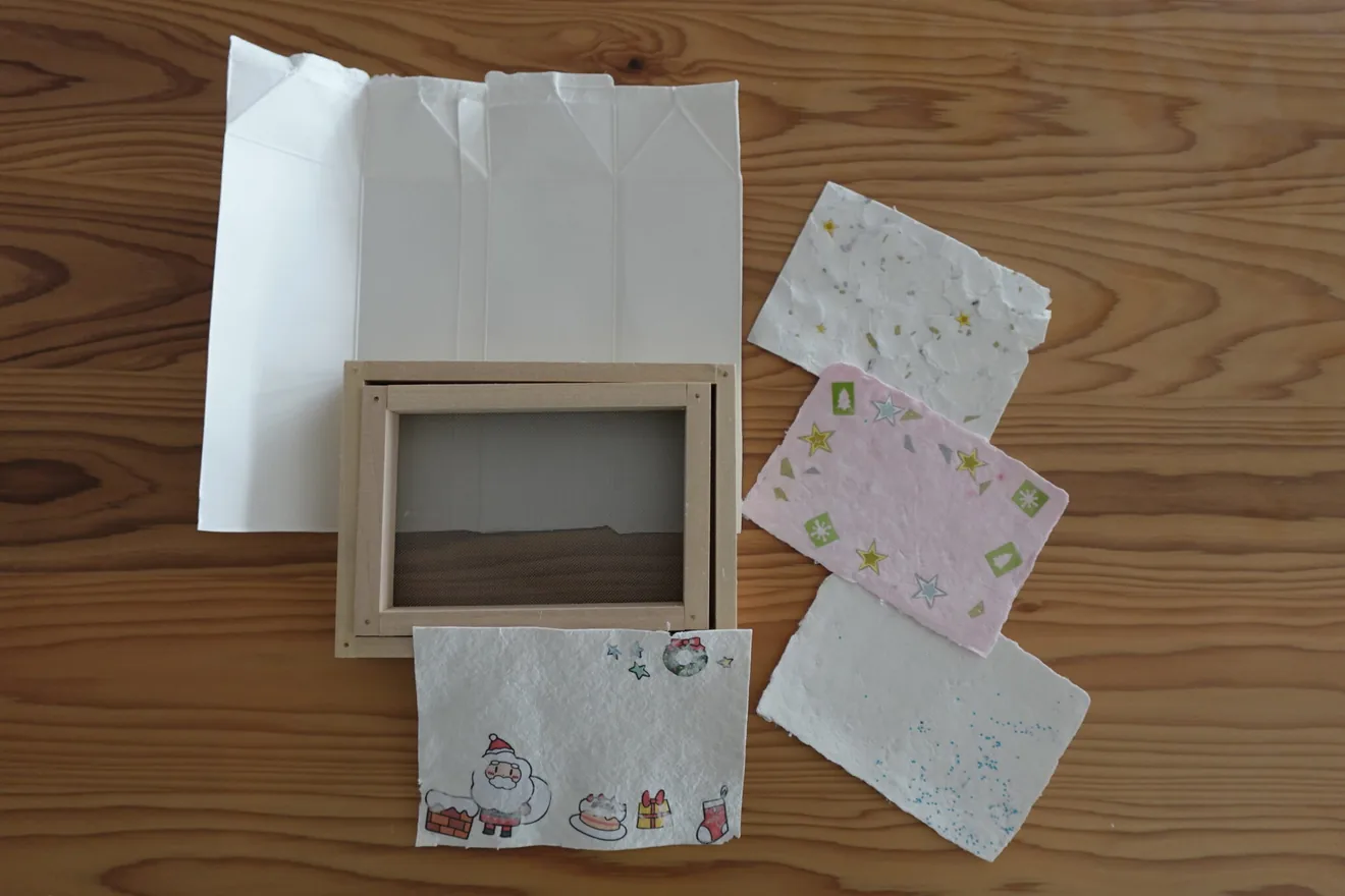 紙すきの道具と飾り付けをした手作りはがきの作品例
